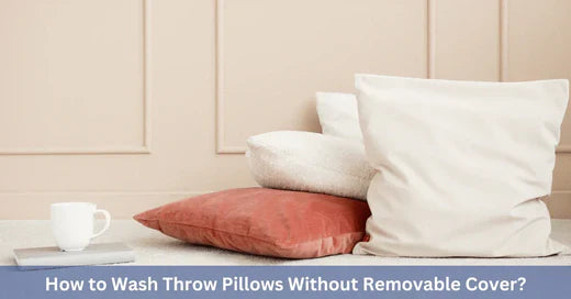 Four throw pillows of varying colors and textures stacked next to a white coffee mug on a minimalist floor setting.