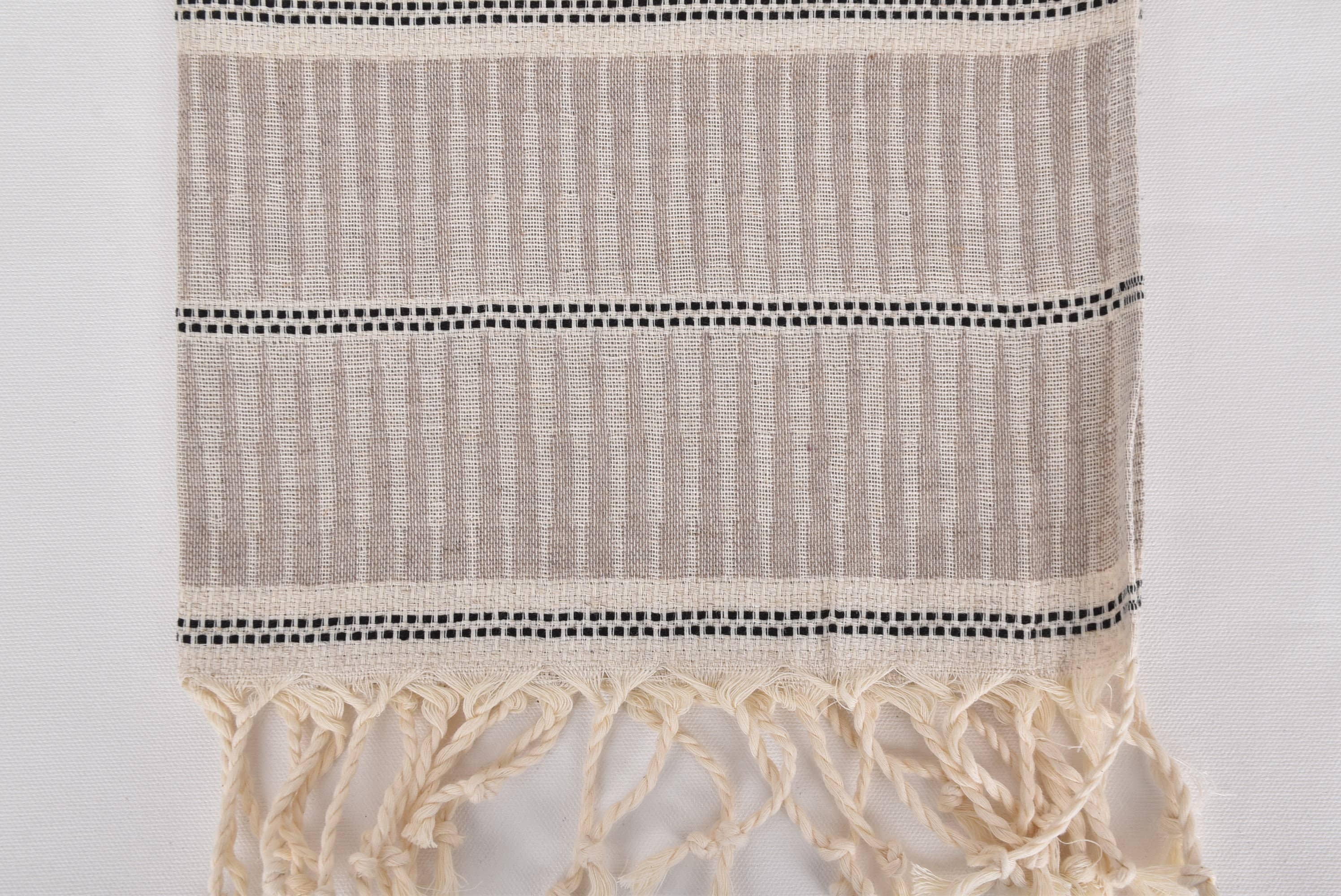 Textile with striped pattern and tassels on a white background