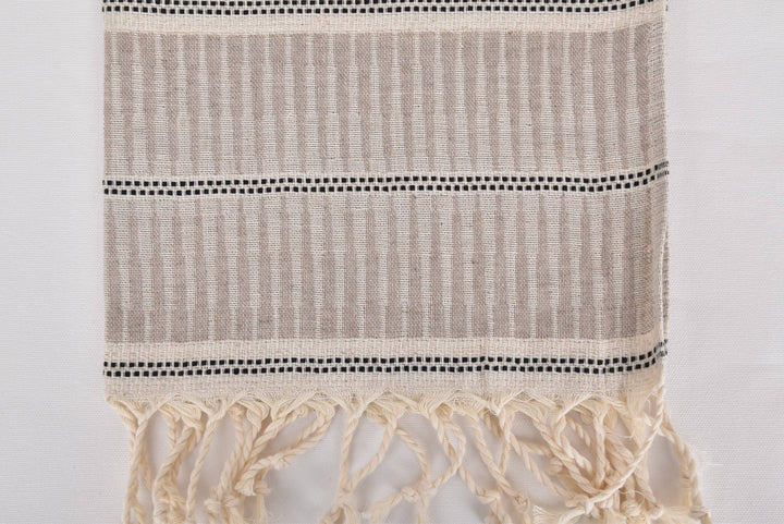 Textile with striped pattern and tassels on a white background