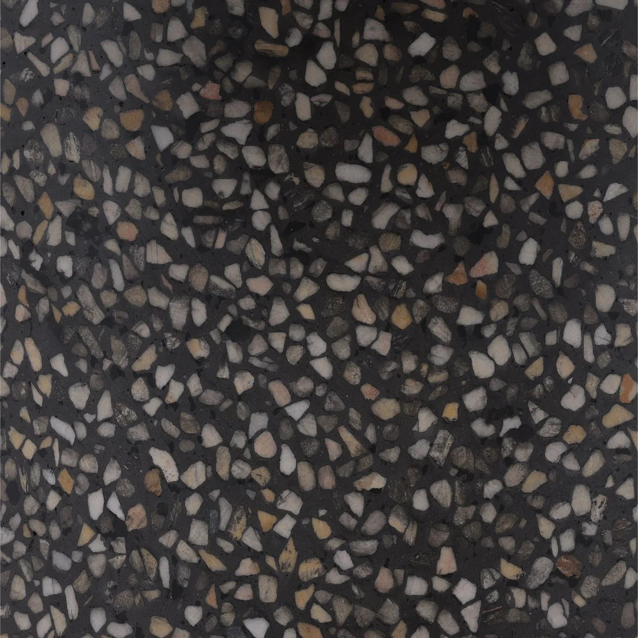 Black terrazzo surface with white gray and tan stone chips, speckled stone texture close up