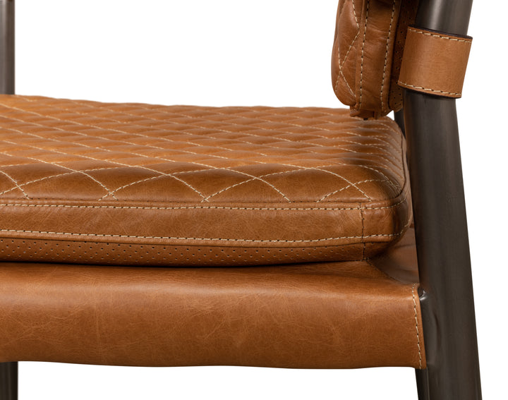 Close up of brown quilted leather chair seat with stitched detailing and metal frame