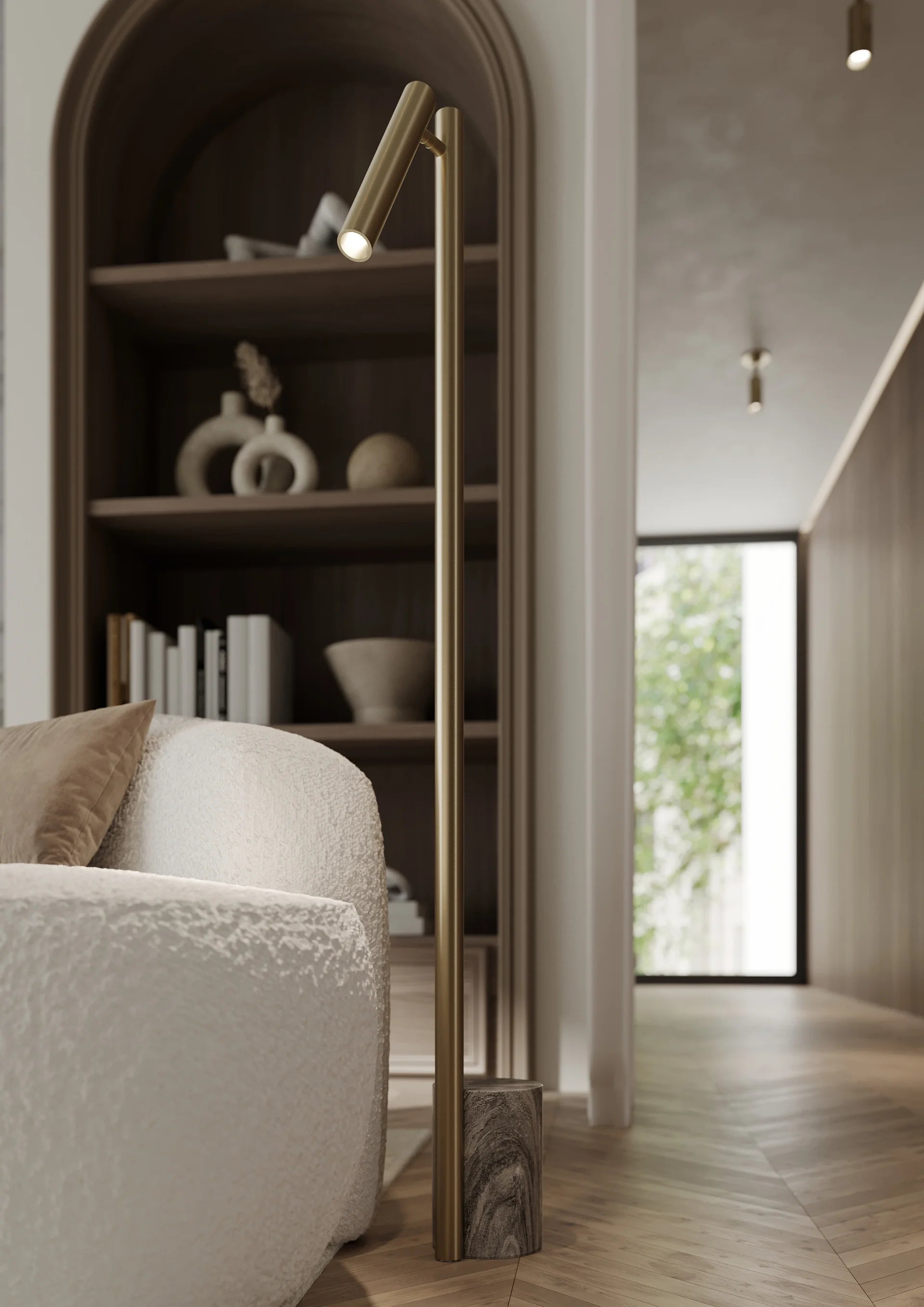 A modern Circleville floor lamp with an articulating shade, featuring a brass finish, mounted in a contemporary interior setting with a bookshelf and lamp in the background.