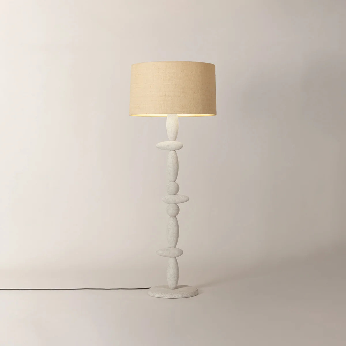 Cullen Floor Lamp with beige drum shade and sculptural white stacked stone base on a light background.