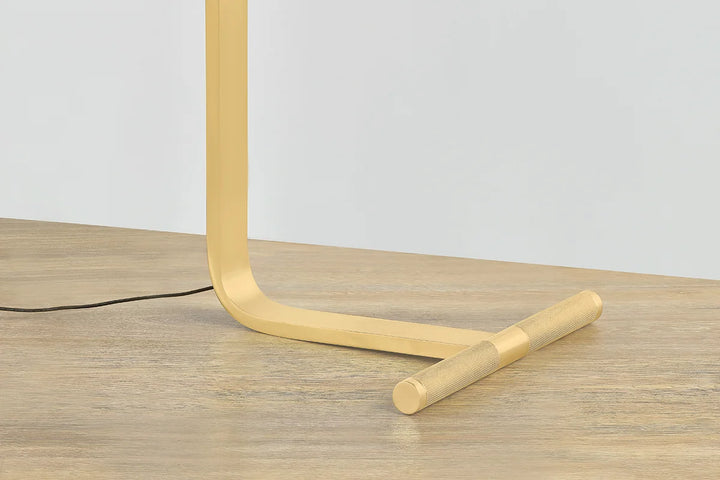 Deptford Floor Lamp: Black dome shade, gold interior, brass joint on white background.