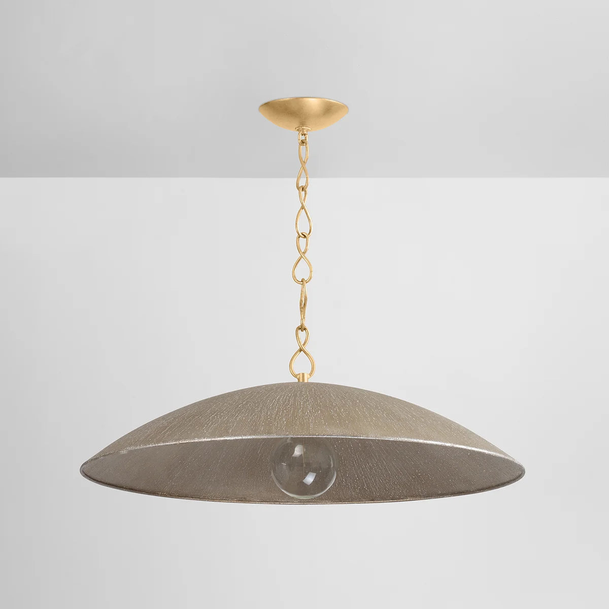 Modern dome pendant light with antique brass chain, wide textured metal shade, and exposed globe bulb on white background