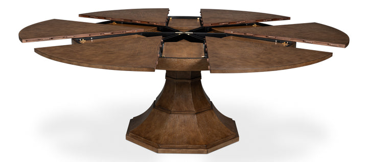 Extendable round wood pedestal dining table opened to show leaf mechanism