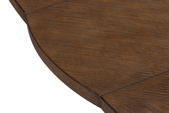 Close-up of round walnut wood tabletop edge with visible grain, beveled rim, and panel joinery detail on modern dining table