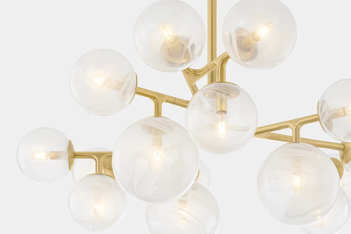Modern brass chandelier with clear glass globe shades and warm exposed bulbs close-up