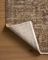 Corner of a patterned rug on a wooden floor