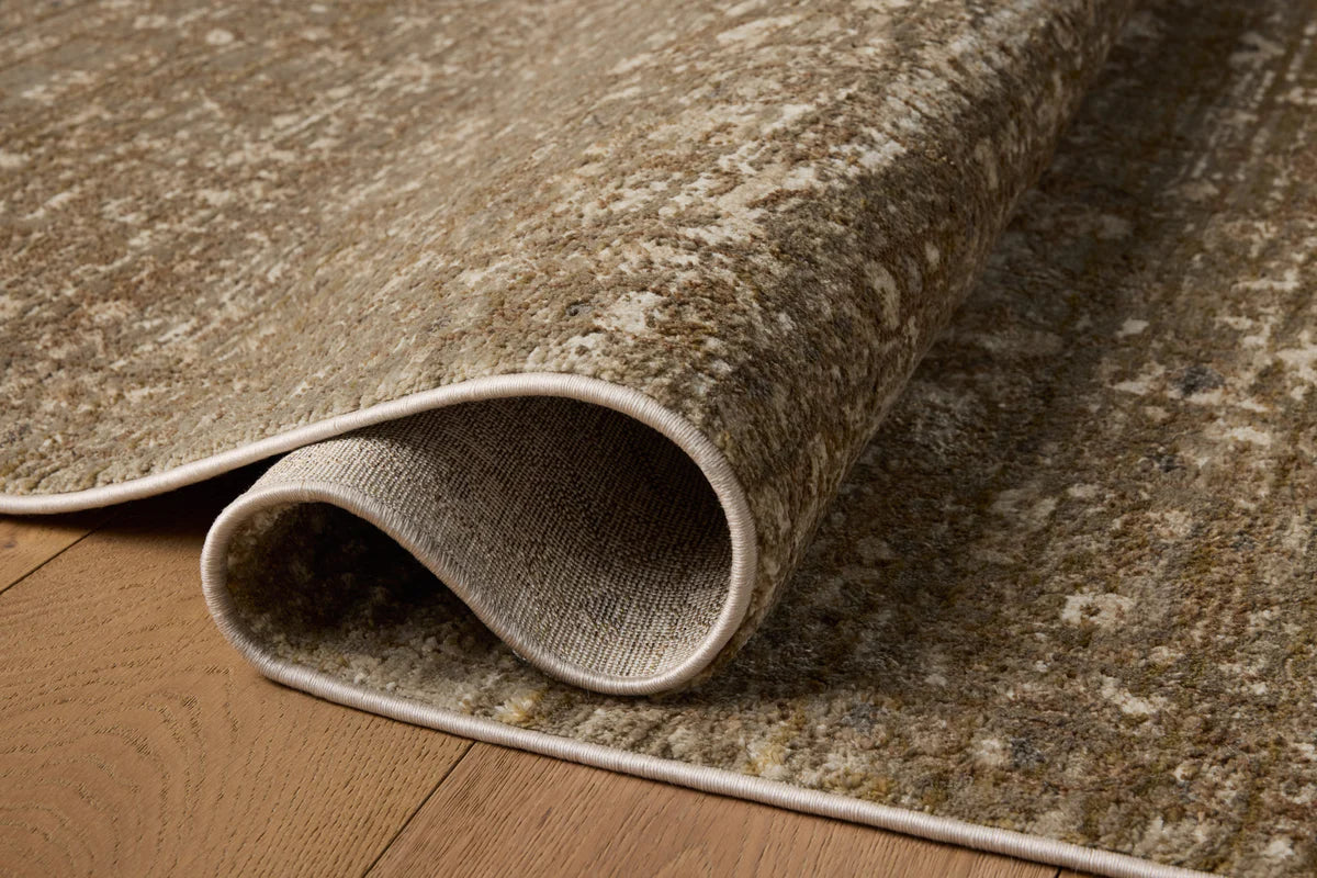 Roll of textured beige carpet on a wooden floor