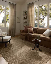 Cozy living room with a brown sofa, armchair, and large windows.