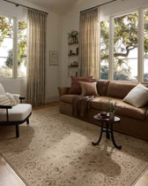 Living room with a brown sofa, armchair, and decorative pillows.
