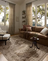 Living room with a brown sectional sofa, armchair, and decorative rug.