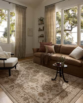 Living room with a brown sectional sofa, armchair, and decorative rug.