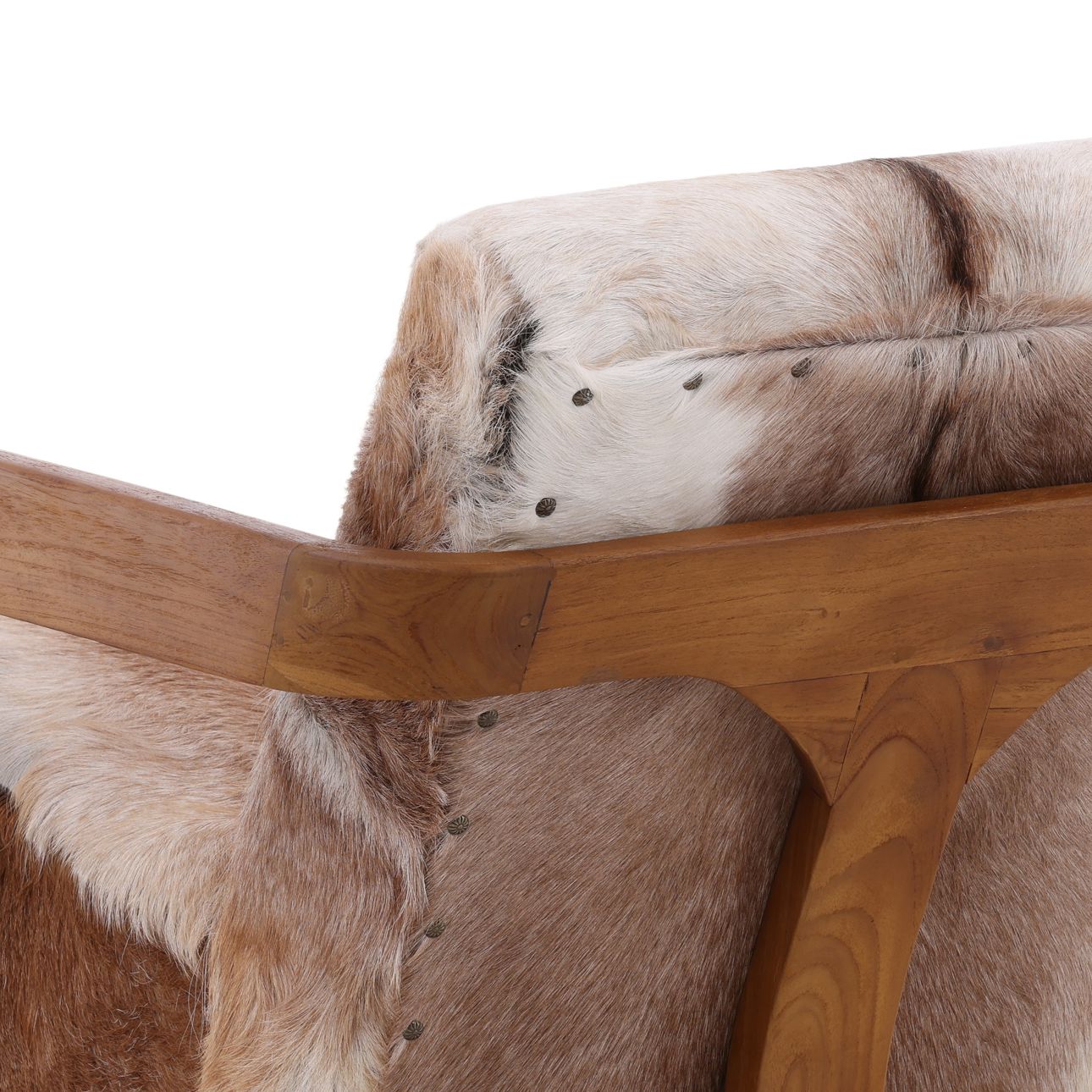 Close-up of cowhide accent chair showing natural fur texture, nailhead trim, and warm wood armrest detail