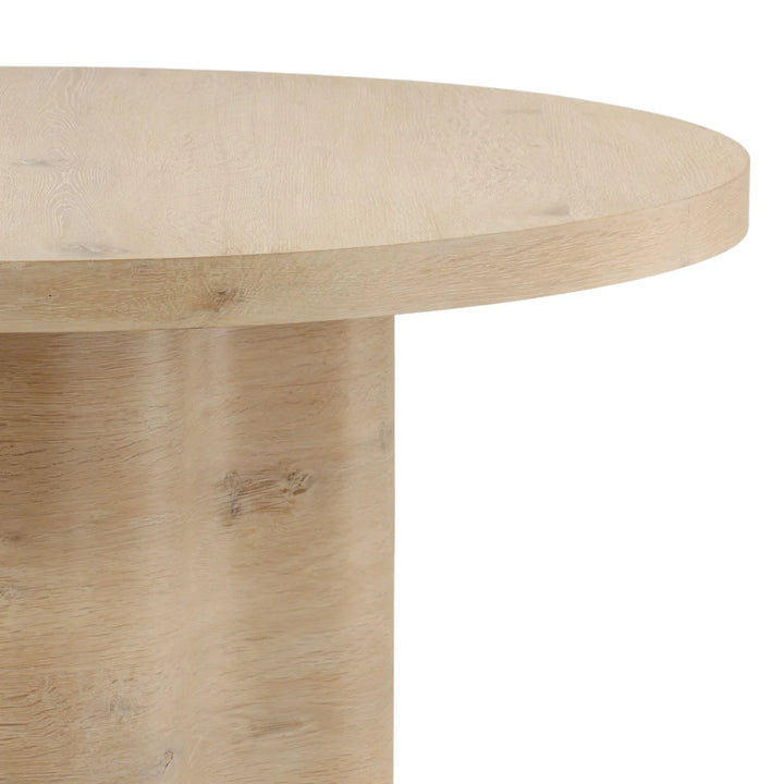 Close up of light wood round table top with pedestal base and natural grain finish