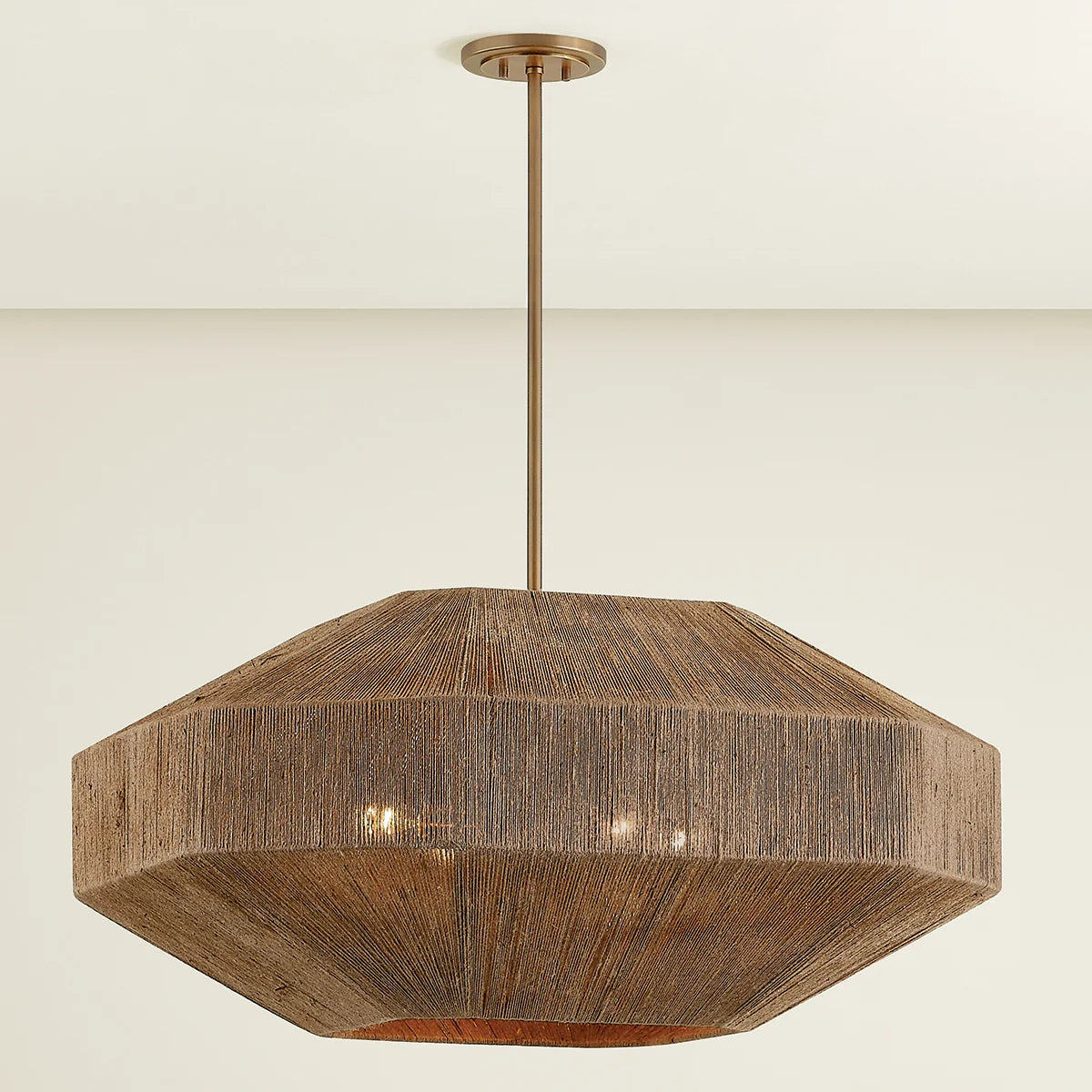 A Laken chandelier with a hand-wrapped jute shade and Patina Brass metalwork, featuring a pinwheel cluster of lights inside.