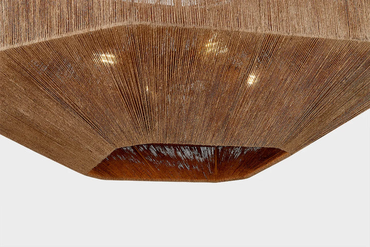 Underside view of woven natural fiber ceiling light with warm glow and textured rattan-style shade
