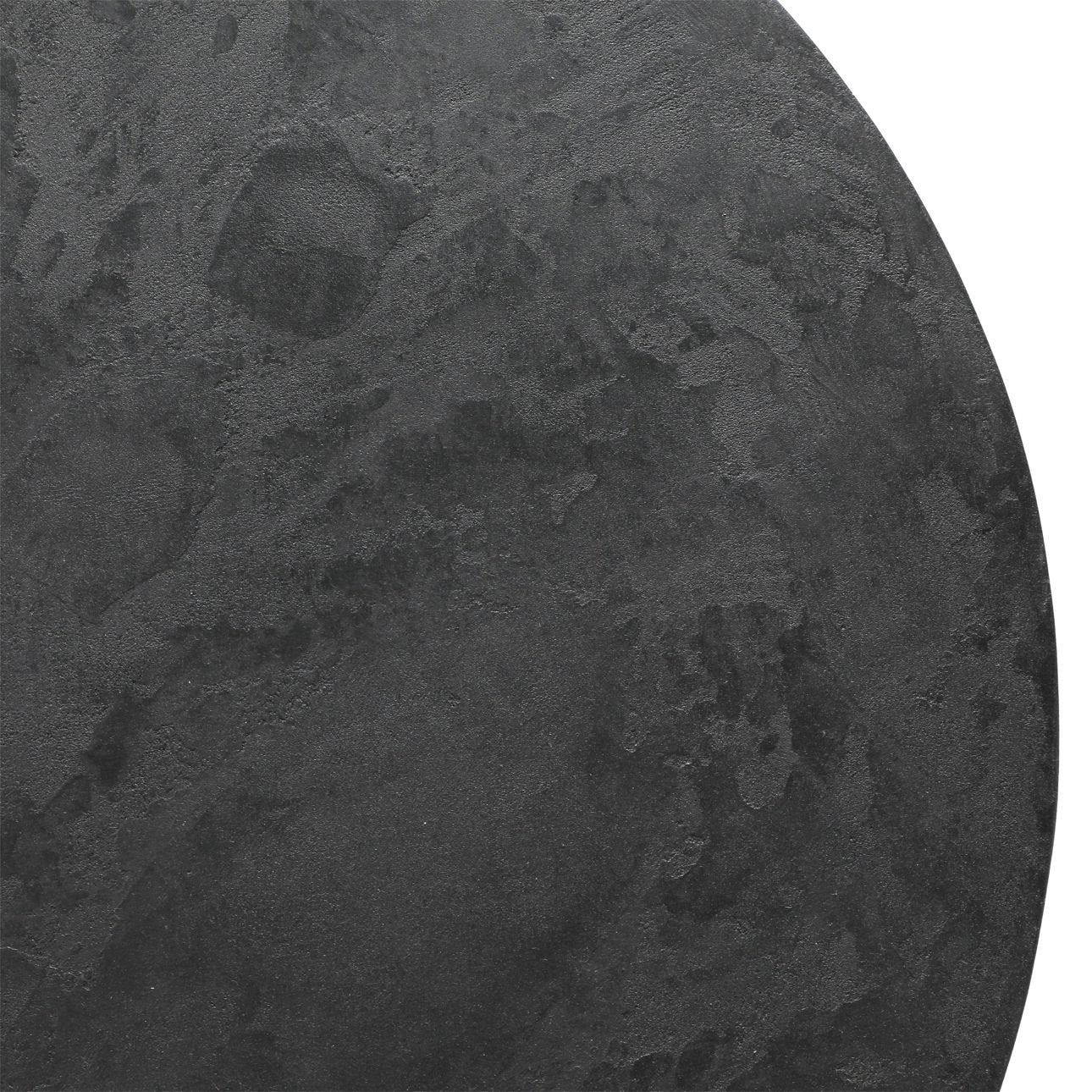 Close up of round black stone tabletop surface with textured matte finish and subtle marbling
