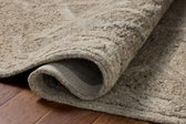 Close-up of a textured beige rug on a wooden floor