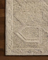 Textured beige rug on a wooden floor