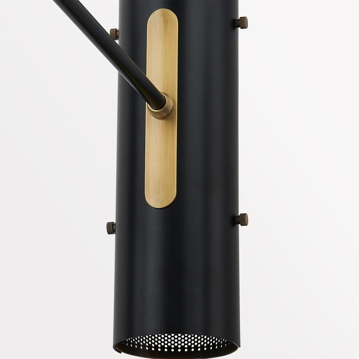 Close-up of black metal wall sconce shade with brass accent plate and adjustable arm hardware, modern lighting fixture detail
