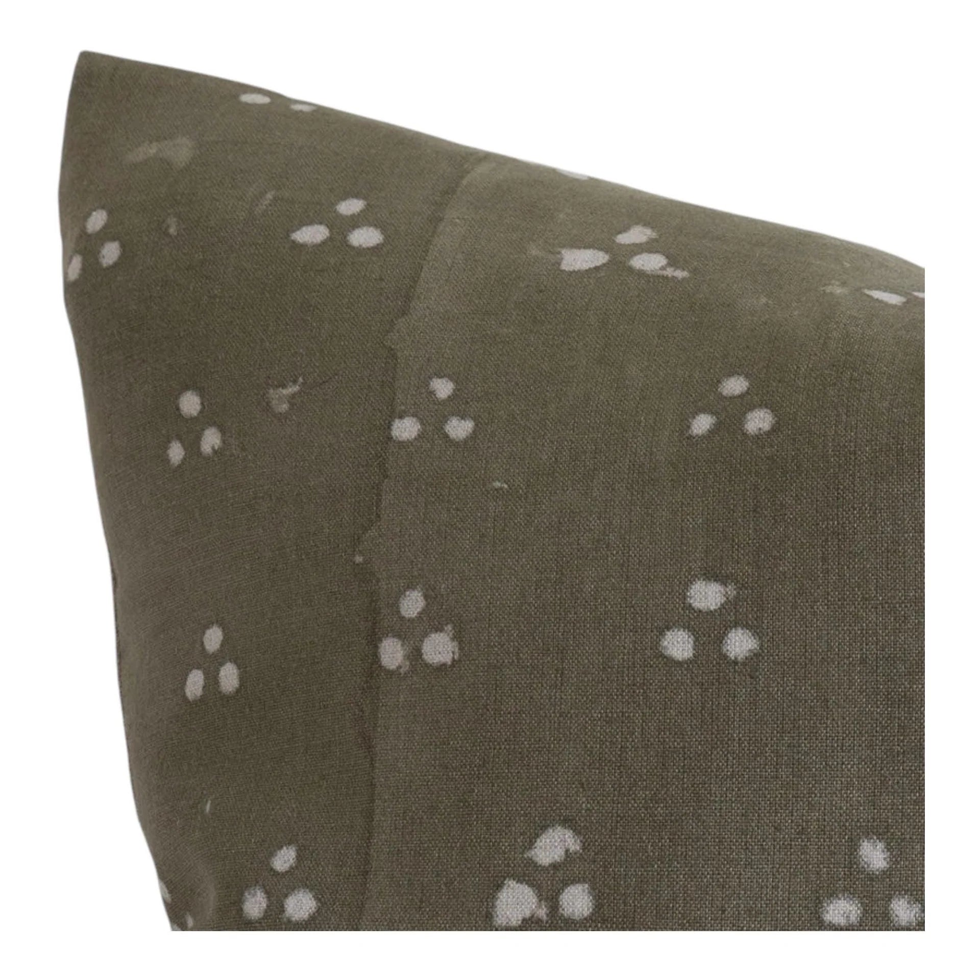 Close up of olive gray throw pillow cover with white dot print and stitched seam detail