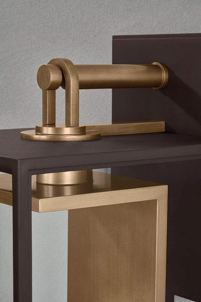 Close-up of outdoor wall lantern showing brass hinge hardware, dark metal frame, and textured panel detail