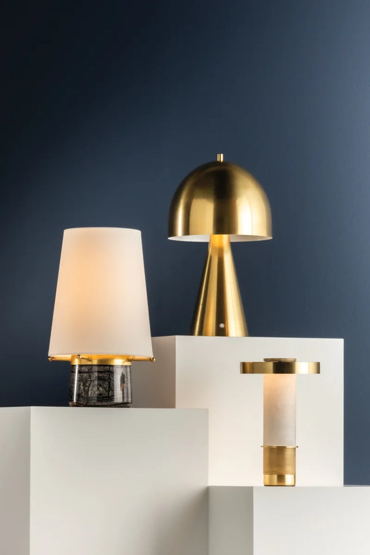 A collection of Sefton portable outdoor table lamps with alabaster and brass accents, displayed in various positions to showcase their designs.