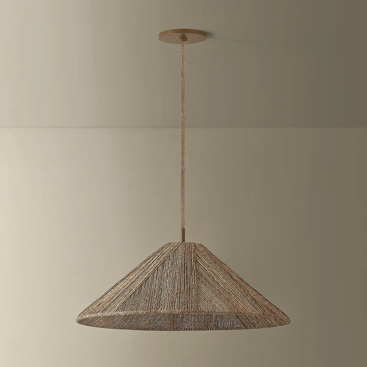 Woven pendant light hanging against a plain wall