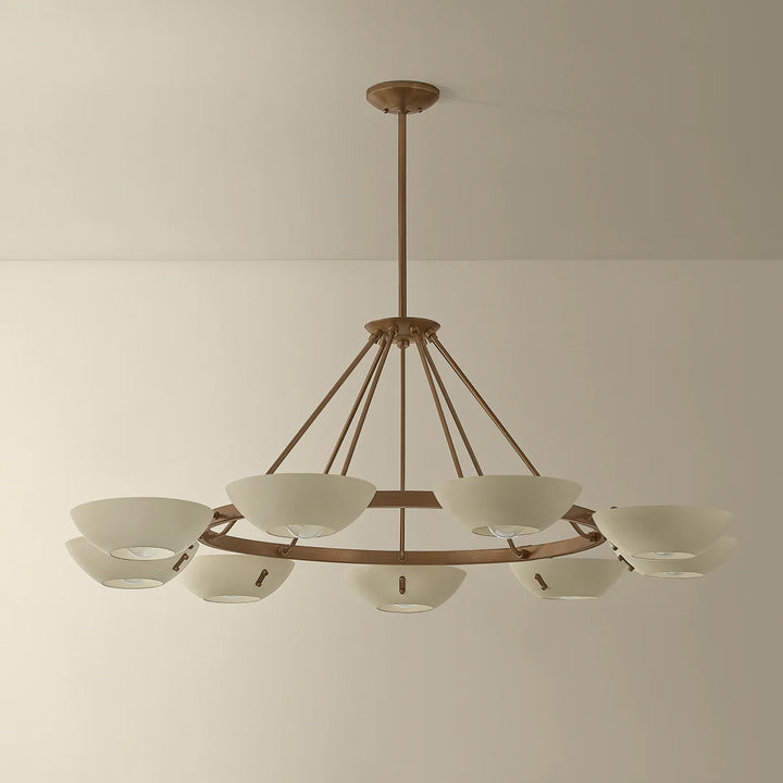 Large brass chandelier with white bowl shades and a circular frame suspended from the ceiling
