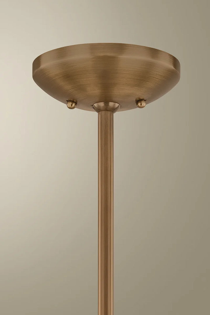 Close-up of an antique brass chandelier canopy and downrod mounted to the ceiling