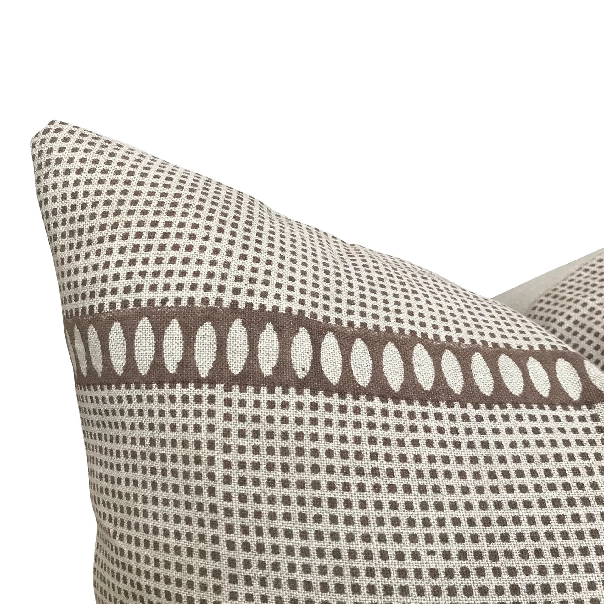 Patterned pillow with brown and beige design on a white background