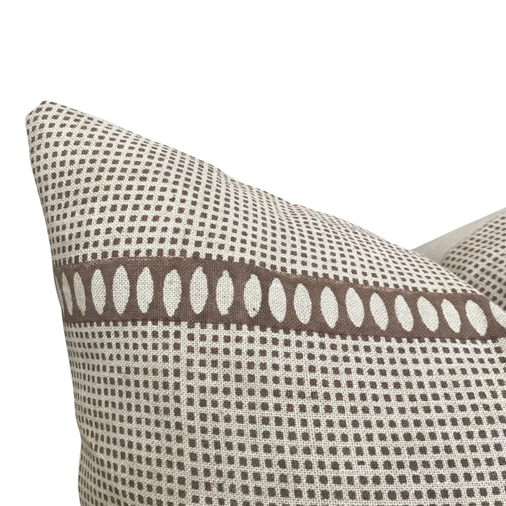 Patterned pillow with brown and beige design on a white background