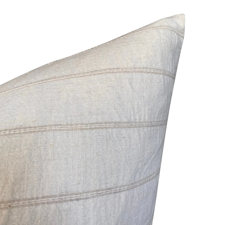 Close-up of a light gray pillow with subtle texture and stitching details on a white background