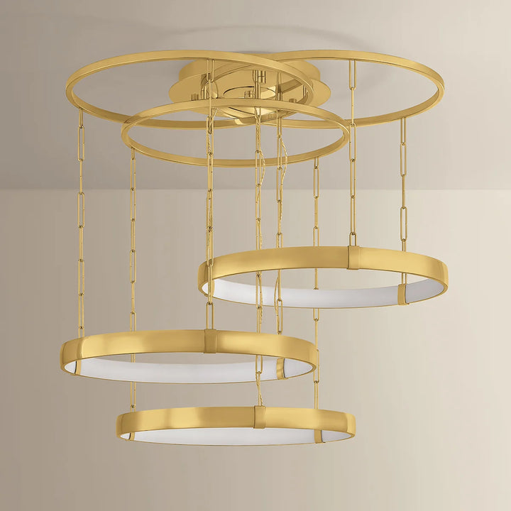 Gold ceiling light fixture with multiple circular shades on a neutral background