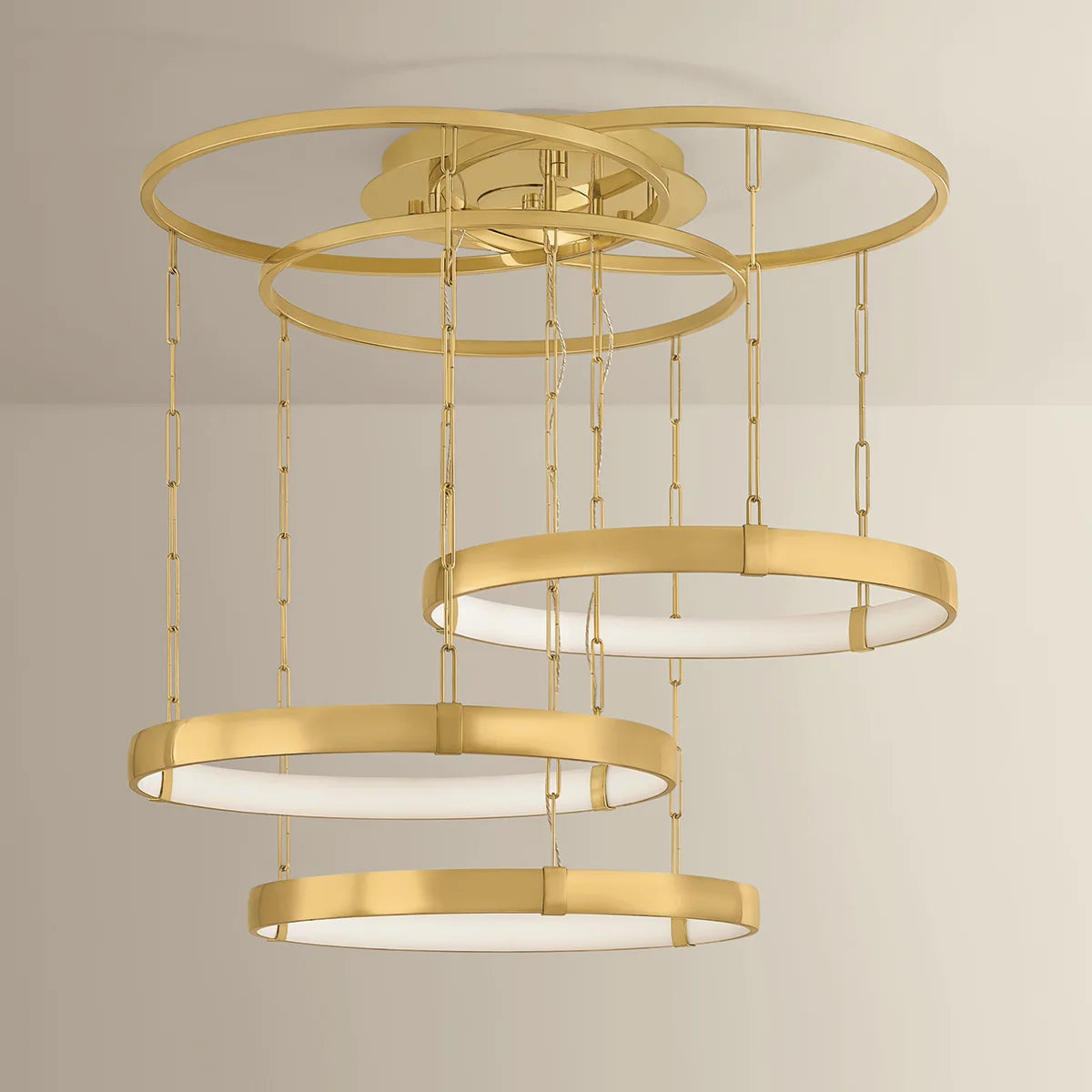 Gold ceiling light fixture with multiple circular rings on a neutral background