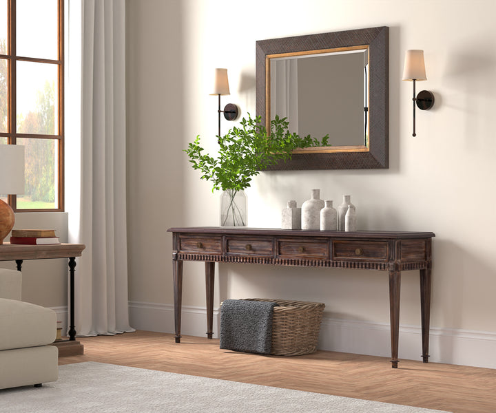 Dark wood console table with wall mirror and matching sconces in entryway