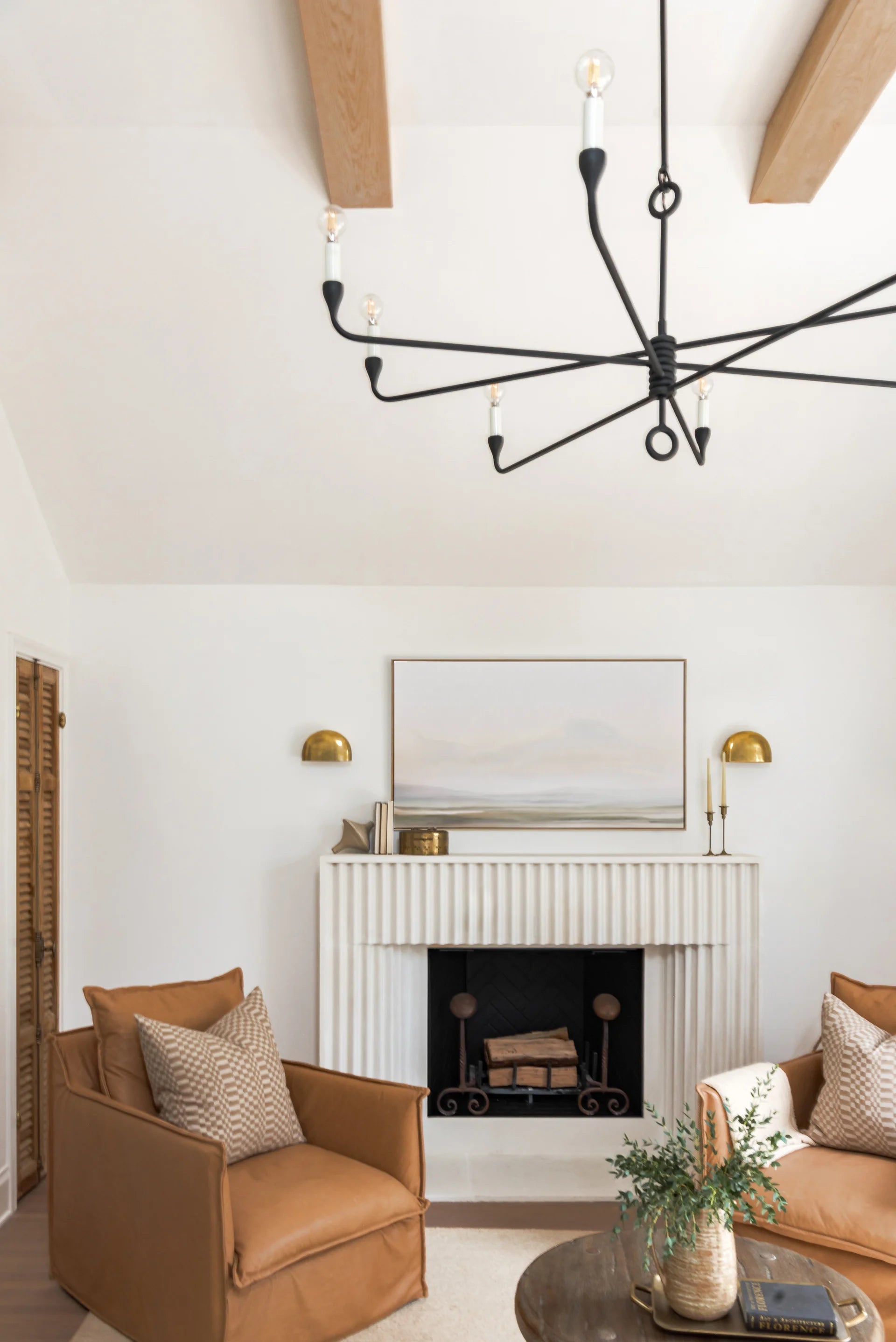Modern living room with a fireplace, brown armchair, and decorative elements.