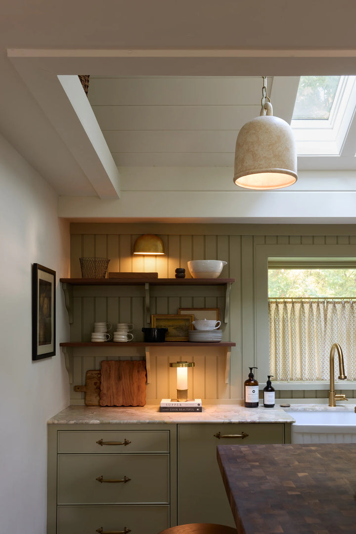 Modern kitchen with pendant light, shelves, and a window.