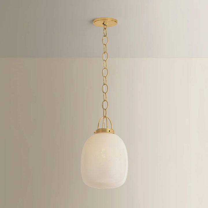 Pendant light with white glass shade and gold fixture on a neutral background