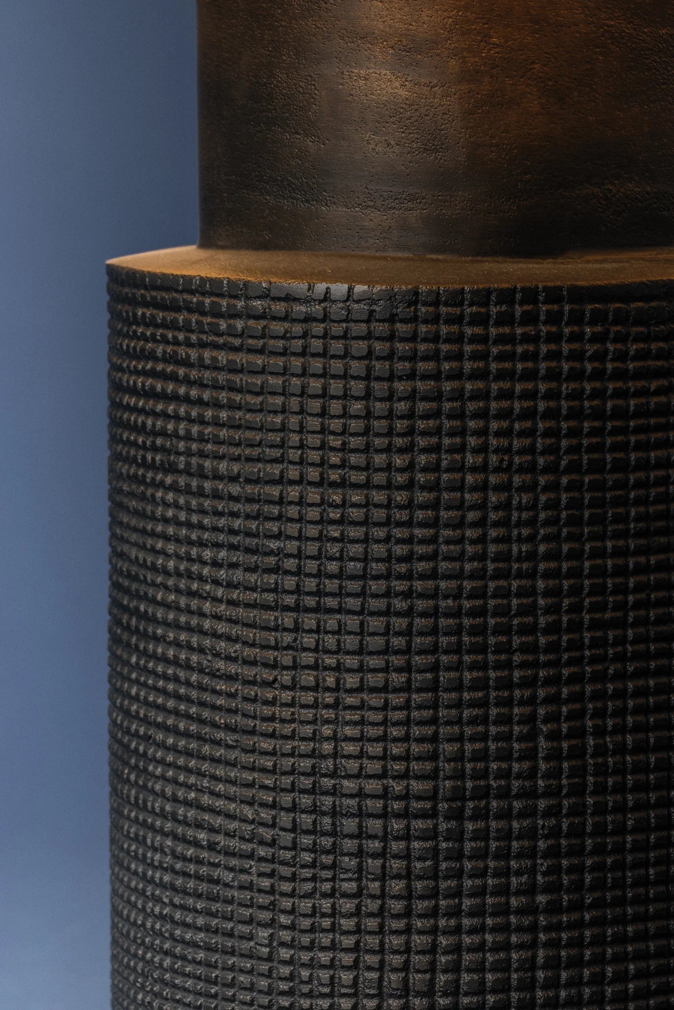 Close-up of a textured cylindrical object against a blue background