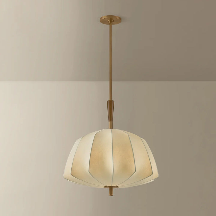 Pendant light with geometric shade and gold fixture on a beige background