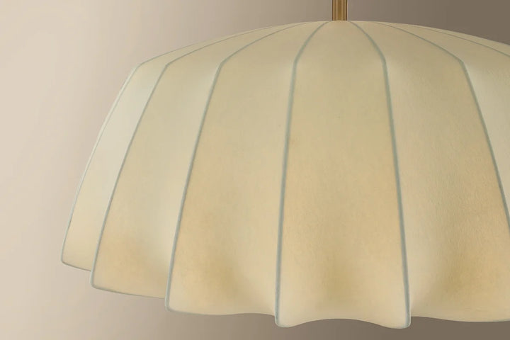 Close-up of a lampshade with a beige color and blue stripes on a plain background