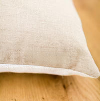 Close-up of a beige fabric pillow on a wooden surface
