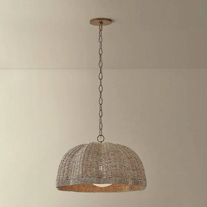 Woven pendant light hanging against a plain wall