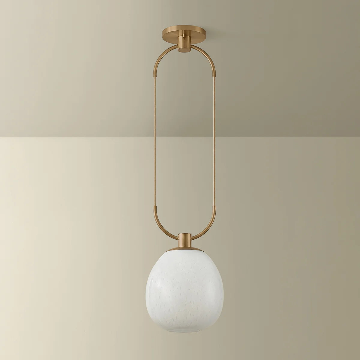 Ceiling light fixture with gold frame and white glass shade on a beige background