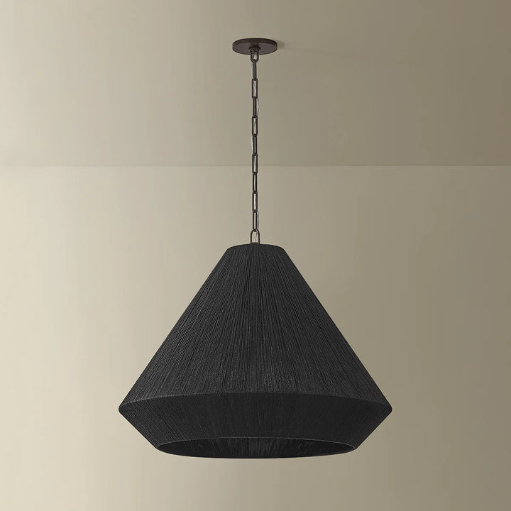 Black pendant light hanging against a beige wall