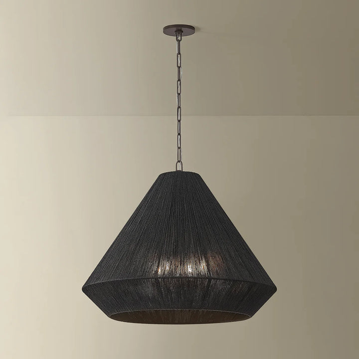 Black pendant light hanging against a beige wall