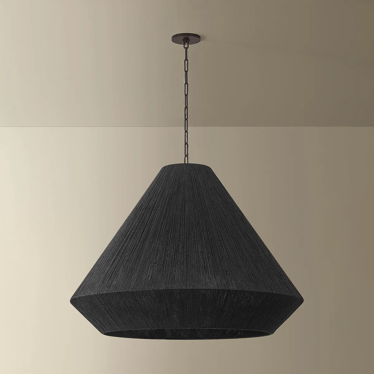 Black pendant lamp hanging against a beige wall